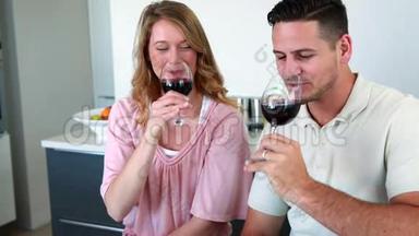 幸福的一对夫妇在镜头前微笑着品尝红酒